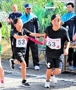 次のランナーへたすきをつなぐ女子児童＝６日、香美町村岡区森脇