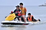 水上バイクで遊泳者を救助し、浜に運ぶ訓練を行う関係者＝５日、岩美町浦富