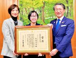 内閣総理大臣賞の賞状を手に平井知事との記念撮影に臨む矢曳さん（中央）＝２２日、米子市の鳥取県西部総合事務所