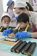 酢飯に具材を乗せて慎重にノリを巻く参加者＝２７日、鳥取市湖山町東２丁目のサンマート湖山店