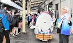 到着した観光列車「はなあかり」の乗客を出迎える「湯～たん」（中央）ら＝６日、ＪＲ浜坂駅