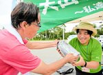 下山して汚泥が入ったボトルを受け渡すボランティア（左）＝１５日、大山町大山