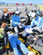 負傷者の「トリアージ」のノウハウを確認する訓練参加者＝３日、鳥取市の鳥取砂丘コナン空港