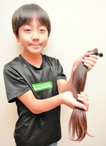 カットした髪の毛を手にする石川君＝２２日、米子市新開７丁目のヘアーサロン　アントレ