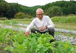 　農園で作業をする元調教師の栗林信文さん＝１０月３日、福島県鮫川村