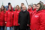 　モスクワの「赤の広場」でボランティアらと記念撮影に応じるロシアのプーチン大統領＝４日（タス＝共同）