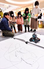 陸上ドローンを使ったお絵描きを体験する参加者ら＝１３日、日吉津村日吉津のイオンモール日吉津