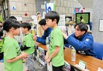 子どもたちが求めるサインに応じる藤田（右）ら＝鳥取県庁