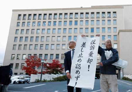 　東北電力女川原発２号機の運転差し止めを求めた訴訟の控訴審判決を受け、仙台高裁前で紙を掲げる原告＝２７日午後