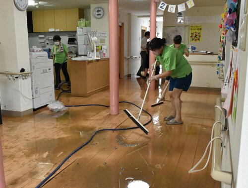 床上２０センチまで漬かった大雨被害の後片付けに追われる職員ら＝１４日、鳥取市福部町湯山のグループホームわかばの家福部