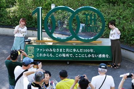 　甲子園球場の１００周年記念モニュメント前で記念撮影する人たち＝１日、兵庫県西宮市