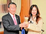 平井知事（左）から記念品を受け取るキムさん＝２２日、米子市糀町１丁目の鳥取県西部総合事務所