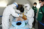傷病者役の男性の放射線量を測定しながら治療する医師ら＝１８日、鳥取市江津の県立中央病院