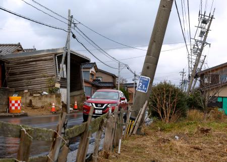 　電柱が傾くなどの能登半島地震による液状化被害が残る石川県内灘町西荒屋地区＝２２日午後