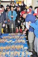 上屋に並べられた松葉ガニを競る仲買人ら＝６日、兵庫県新温泉町の浜坂漁港