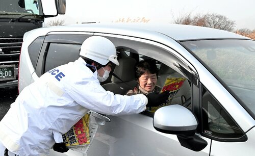 啓発グッズの入ったチラシを渡し、安全運転を呼びかける鳥取署員