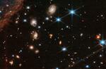　ジェームズ・ウェッブ宇宙望遠鏡で撮影した「？」形の天体（中央）。合体しつつある銀河とみられている（ＮＡＳＡなど提供・共同）