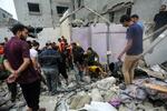 　イスラエル軍の空爆で倒壊した建物のがれきの中を捜索する人々＝２９日、パレスチナ自治区ガザ南部ハンユニス（ゲッティ＝共同）