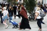 　フランス・ナントで歩くアバヤ姿のイスラム教徒女性（中央）＝８月２９日（ロイター＝共同）