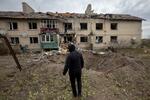 　７日、ウクライナ東部ハリコフ州で、ロシアのミサイル攻撃によってできた穴を見つめる男性（ロイター＝共同）