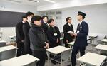 　警視庁の警察学校を見学し、職員から説明を受ける試験合格者ら＝２月、東京都府中市