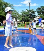 涼を求め公園の噴水で水遊びをする子どもたち＝２１日、鳥取市戎町の真教寺公園