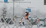 　雪の中、「竹島の日」式典会場周辺で警戒する警察官＝２２日午後、松江市