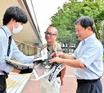 石破首相誕生を伝える特別号外を受け取る市民ら＝１日、ＪＲ鳥取駅前