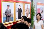 　北朝鮮の建国７５年を祝う写真展で展示された金正恩朝鮮労働党総書記の写真（中央）。左は故金日成主席、右は故金正日総書記の写真＝４日、平壌（共同）