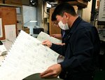 刷り上がった投票用紙に印刷のミスがないか確認する印刷会社の社員ら＝１５日、松江市内