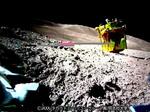 　月面でメインエンジンが上を向いた状態の探査機「ＳＬＩＭ（スリム）」（右上）。分離した超小型変形ロボット「ＳＯＲＡ―Ｑ（ソラキュー）」が撮影した（ＪＡＸＡ／タカラトミー／ソニーグループ（株）／同志社大提供）