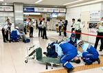 　大阪・関西万博に備え実施された防犯訓練で、負傷者を救護する消防隊員ら＝３１日午前、大阪メトロなんば駅