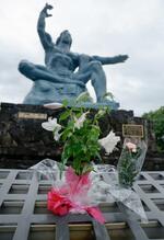 　「平和祈念像」の前に供えられた花。雨にぬれていた＝９日午前、長崎市の平和公園