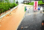 道路に土が流入し、一時全面通行止めとなった＝１５日午後０時２６分、鳥取市用瀬町