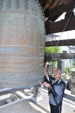 平和への祈りを込めて鐘を突く谷本住職＝１５日、鳥取市寺町の浄土宗・本願寺