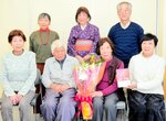 出版を祝う仲間から花束を受け取った有田さん（前列左から３人目）