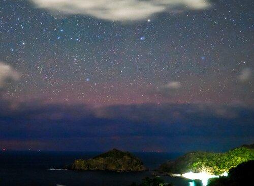 雲の下方に赤っぽく写る「低緯度オーロラ」＝１日午後１０時１７分、松江市美保関町惣津（寺沢さん撮影）