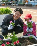 　キャンプ最初の休日、地元小学生と一緒に花を植えるオリックス・麦谷＝宮崎市