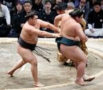 　霧島（左）が送り出しで錦木を下し、勝ち越しを決める＝福岡国際センター