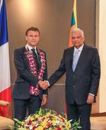 　２８日、スリランカのウィクラマシンハ大統領（右）と握手するフランスのマクロン大統領＝コロンボ（スリランカ大統領府提供・ＡＰ＝共同）