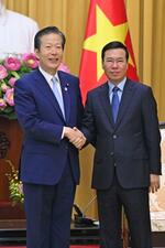 　ベトナム・ハノイでボー・バン・トゥオン国家主席（右）と握手する公明党の山口代表＝２３日（共同）