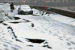 　雪が降り積もる、石川県輪島市のひび割れた道路＝１３日午後