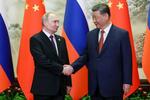 　握手を交わすロシアのプーチン大統領（左）と中国の習近平国家主席＝１６日、北京（タス＝共同）