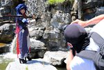 滝をバックにコスプレ写真の撮影をする参加者ら＝１８日、湯梨浜町の中国庭園燕趙園