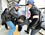 テロ対策合同訓練で、犯人の制圧に当たる智頭署員ら＝２１日、智頭町智頭の智頭急行智頭駅