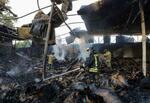 　２４日、ウクライナ東部ドネツク州で、戦闘で破壊された建物を消火する消防士ら（ロイター＝共同）