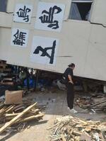 　石川県輪島市で倒壊したビルを眺める楠さん＝２０２４年５月２６日