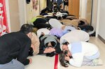 体を縮める「だんごむしのポーズ」で身を守る児童＝３０日、日吉津村日吉津の日吉津小