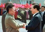 　２０００年６月、平壌国際空港に到着した韓国の金大中大統領（右）と初の握手を交わす北朝鮮の金正日総書記（韓国取材団・共同）