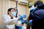 　第一三共の新型コロナウイルスワクチンを接種する田幡雅彦院長（左）＝１３日午後、東京都板橋区